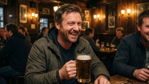 Ricky Gervais savourant une pinte et un rire dans un pub chaleureux.