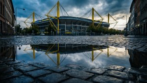 Riflesso del Signal Iduna Park in una pozzanghera piovosa, atmosferico e cinematografico