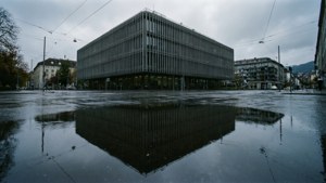 Symmetrisk refleksjon av ETH Zurichs hovedbygning i en regndam med dyster himmel