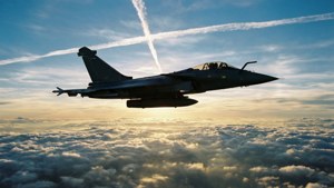 Pesawat tempur Rafale terbang di atas awan saat matahari terbit.