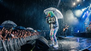 Pertunjukan hujan dramatis dengan Marshmello dan Kane Brown di bawah payung.
