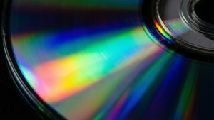 Nærbilde av en DVD-plateoverflate med regnbue refleksjon fra lys.