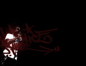 Rapper performing on stage with red graffiti text behind him. — Rap Wallpaper