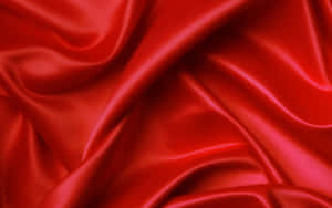 Primer plano de tela de satén rojo fluyendo con reflejos brillantes y pliegues suaves — Fondos rojos y verdes Fondos