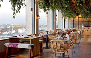 Dachrestaurant mit Korbstühlen und Holztischen mit Blick auf die Stadtlandschaft durch große Fenster. — Bilder Aus Der Innenstadt Wallpaper