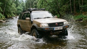 Daewoo Winstorm traversant une rivière sur un sentier tout-terrain.