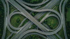 Top-down view of cloverleaf road loops in green and gray. — Loop Picture