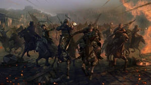 Warriors on horseback charge through a burning city street in a chaotic battle.