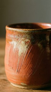 Primo piano di una tazza in ceramica rustica strutturata.