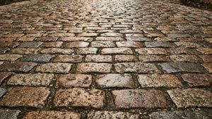 Jalan berbatu granit rustik yang hangat dari balok granit tidak rata, pesona dunia lama