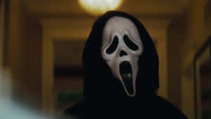 A masked horror figure in a dark hallway with warm lighting. — No You Hang Up Scream Picture