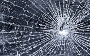 Shattered glass with cracks radiating from a central impact point. — Color Illusion Picture