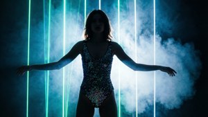 Kvinne i paljettbody silhuett mot vertikal laservegg på rave