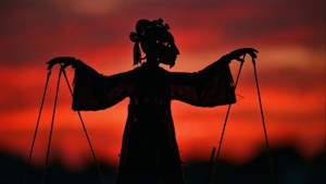 A shadow puppet silhouette against a red sunset.