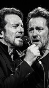 Bono und The Edge aus nächster Nähe teilen sich ein Mikrofon, emotionales Schwarz-Weiß.