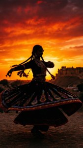 Silhouette de danseuse au coucher du soleil au Jaisalmer Desert Festival.