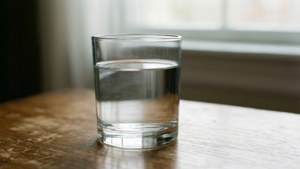 Una foto pulita di un bicchiere d'acqua, con attenzione alla purezza e alla semplicità.