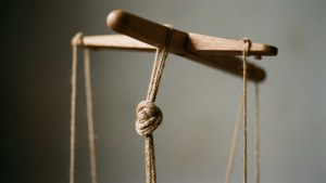 Gros plan d'une ficelle de marionnette et d'une barre de contrôle avec bokeh.