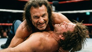 Two wrestlers locked in a fierce grappling match inside a ring.