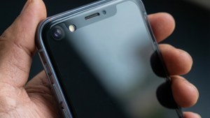 Makro nærbilde av hånd som holder telefon med refleksjon