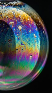 A colorful soap bubble with swirling patterns against a black background. — Qled Wallpaper