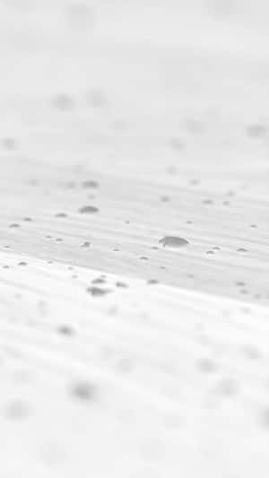 Gros plan de gouttelettes d'eau sur une surface en bois gris clair avec une faible profondeur de champ.