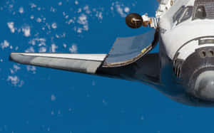 Aile et nez de navette spatiale contre Terre bleue avec nuages