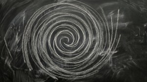 Blackboard with illegible chalk spiral pattern, smudges, creative.