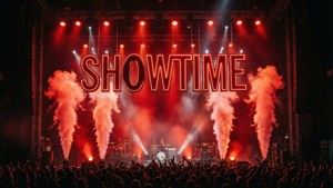 Concertpodium met reusachtige SHOWTIME-letters boven rook en licht