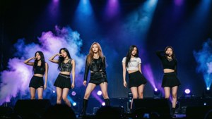 Wallpaper konser epik dari (G)I-DLE dengan pencahayaan dramatis.