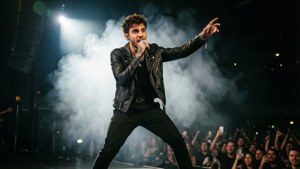 Zayn Malik opptrer live på scenen med dramatisk belysning.