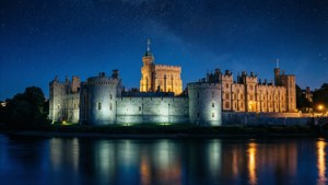 Windsor Castle om natten med skinnende lys reflekteret i Themsen.