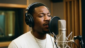 Polo G singing in the studio with headphones, warm tones. — Polo G Background