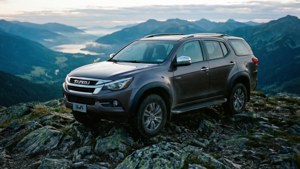 Isuzu Mu-x vuorenhuipulla sumuisen laaksonäkymän kanssa.