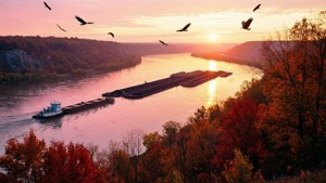 Vista del amanecer desde un acantilado alto sobre el río Mississippi con remolcador y barcazas