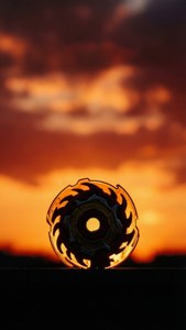 Minimalistisk Beyblade X silhuet ved solnedgang.