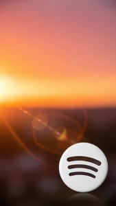 Wit Spotify-logo in de hoek van een zonsonderganggradiëntachtergrond