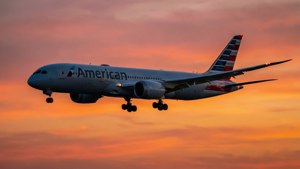 American Airlines plane landing at sunset with orange and pink sky — American Airlines Wallpaper