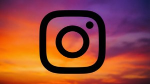 Ein schwarzes Instagram-Logo über einem wunderschönen sonnenuntergangsfarbenen Verlaufshintergrund.
