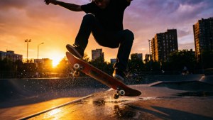 Skateboarder som gjør kickflip ved solnedgang