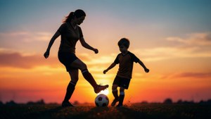 Silhuett av en fotballmamma som spiller fotball med barnet sitt ved solnedgang.