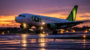 Gol Linhas Aereas -lentokone laskeutuu auringonlaskussa hehkuvien kiitotievalojen kanssa.