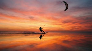 Kitesurfer silhuett ved solnedgang, rolig og minimalistisk bakgrunn