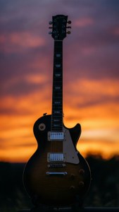 Les Paul -kitaran siluetti värikästä auringonlaskua vasten.