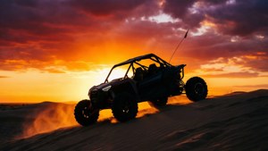 Een strandbuggy-silhouet tegen een vlammende zonsonderganglucht.