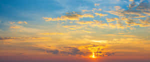 Puesta de sol con nubes doradas y cielo azul sobre el horizonte — Vista del atardecer Fondos de pantalla