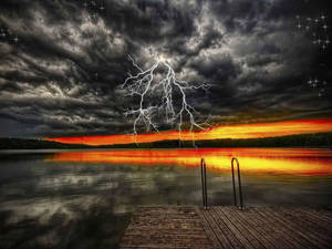 A wooden dock at sunset with a lightning strike over a stormy lake.