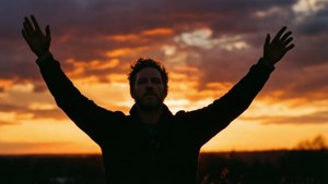 Siluet Matt Lindland yang merayakan saat matahari terbenam