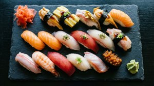 Overhead view of a vibrant sushi platter with nigiri, maki, and garnishes.