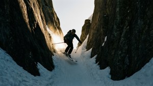 En skiløper navigerer en smal, steinete skrent med intens fokus.